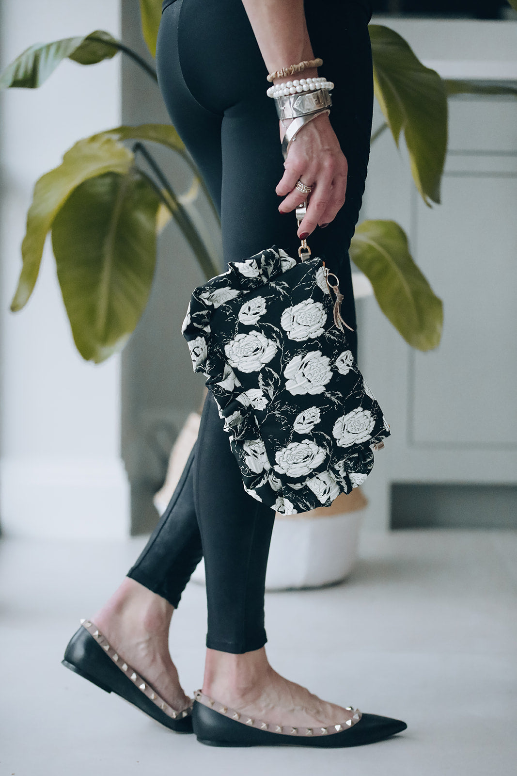 The Dolly Black & Cream Rose Damask Frilly Edge Bag is handcrafted in England from elegant black and cream rose damask brocade, finished with a baby pink moiré lining, yellow gold zip and gold hardware. Complete with a gold leather wrist strap and bespoke gold chain, it can be worn as a clutch, shoulder or crossbody bag for weddings, festivals, holidays and timeless everyday style.